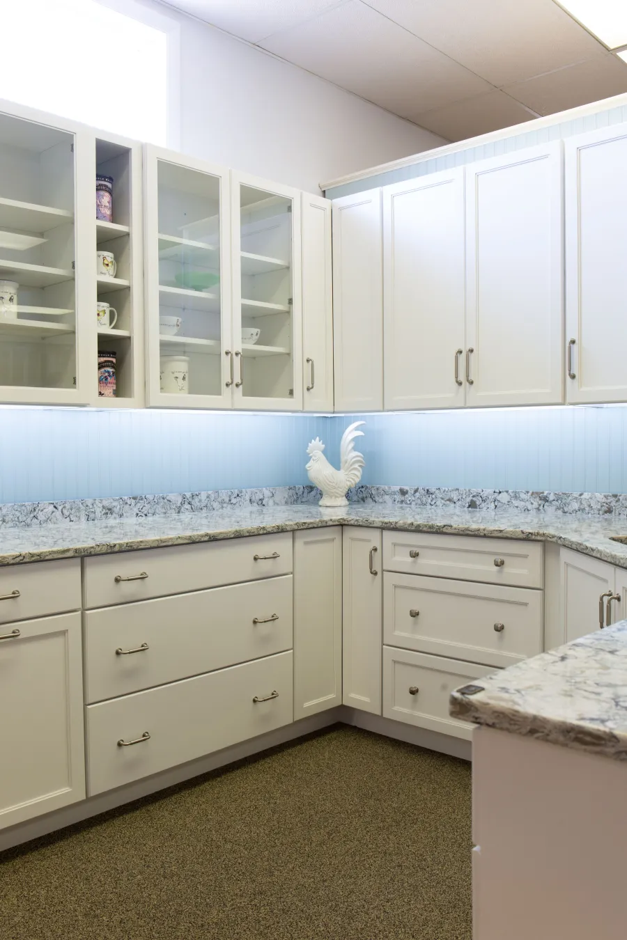 White shaker kitchen with granite countertops and under-cabinet lighting